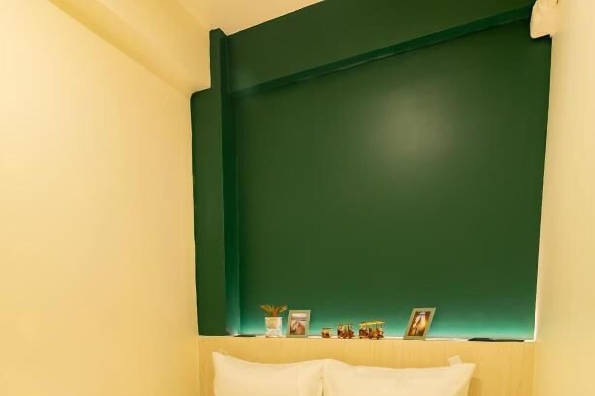 Ein Hotelzimmer mit einem Bett, Kissen und einem Kopfteil.
