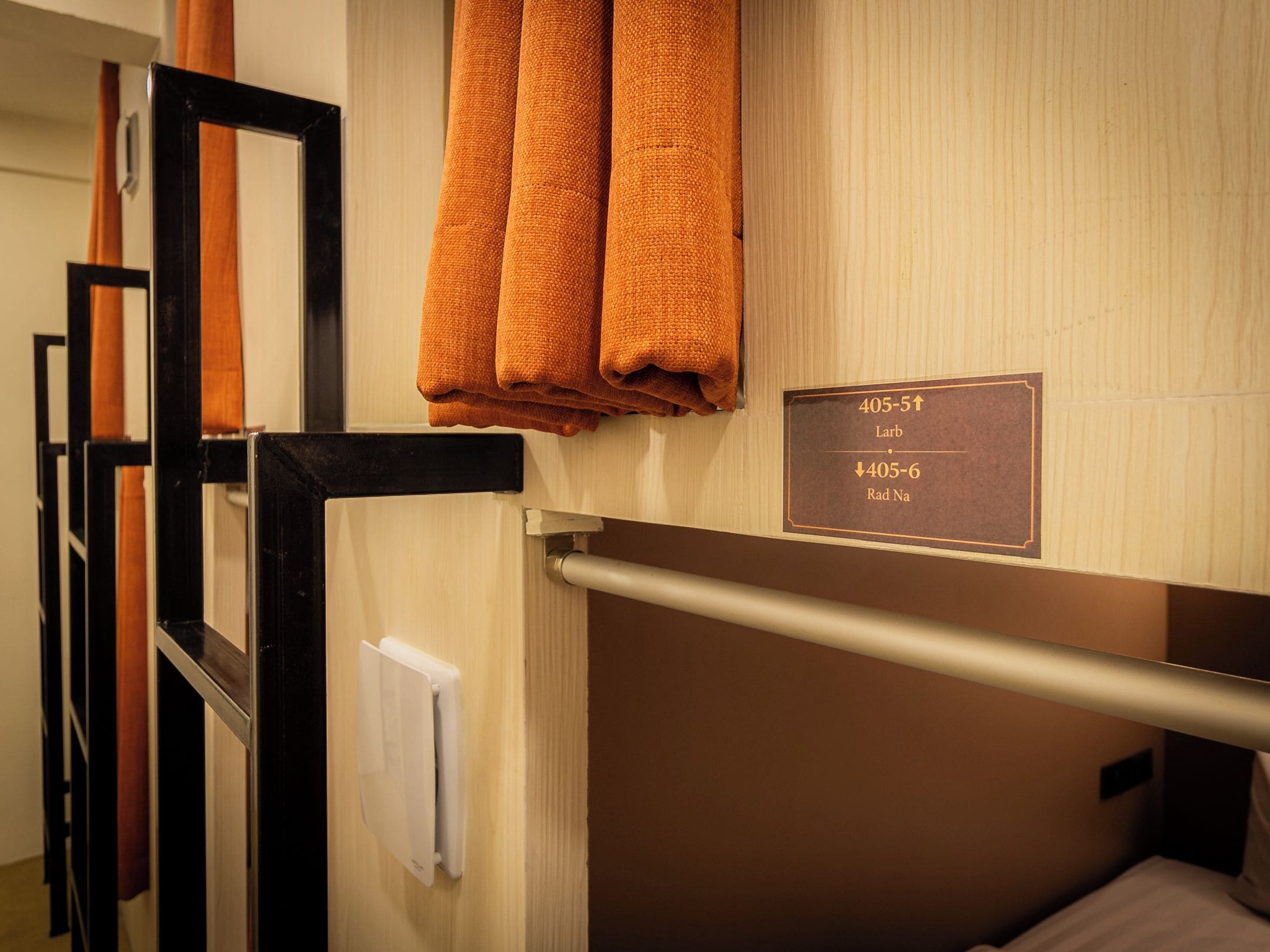 A hotel room with a bunk bed, a towel rack with folded towels, and a sign indicating room numbers 405-51 and 405-6.