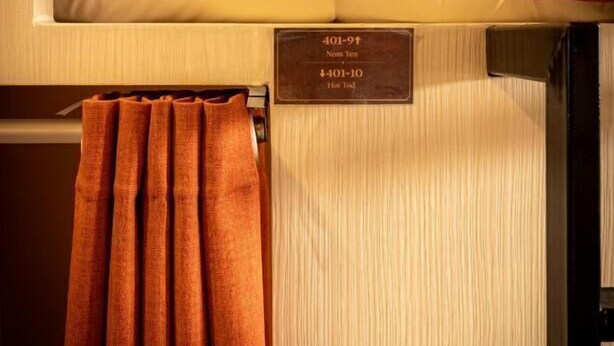 Quarto de hotel com beliche e placa indicando os números de quarto 401-9 e 401-10.