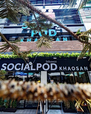 A building with a sign that reads 'SOCIAL POD KHAOSAN' and a view of the interior through the windows. -  Social Pod Khao San Hostel (Bangkok)