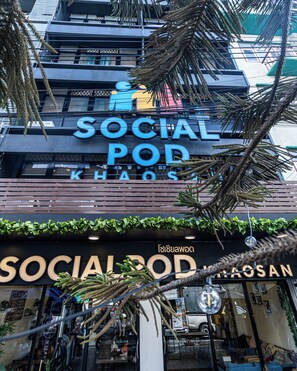 Un edificio con un letrero que dice 'SOCIAL POD KHOS' y otro letrero debajo que dice 'SOCIAL POD'.