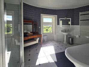 Un baño con lavamanos blanco, espejo, inodoro y bañera.