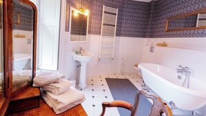 A bathroom with a freestanding bathtub, a sink, and a mirror. - Château de l'Isle Marie (Picauville)