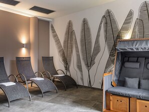 A room with reclining chairs, a massage table, and a wall with feather patterns. - Apartement Luxury Penthouse by Interhome (Viehhofen)