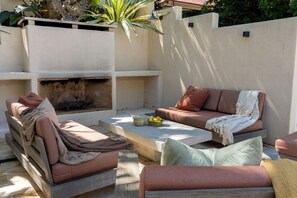 An outdoor seating area with a fire pit, cushioned seating, and a table with fruits. - VIMANA - Perfect summer getaway for large groups - Mullumbimby (Mullumbimby)