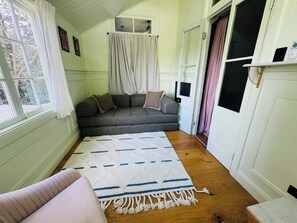 A cozy room with a grey sofa, a white rug with blue patterns, and a wooden floor. - VIMANA - Perfect summer getaway for large groups - Mullumbimby (Mullumbimby)