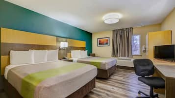 A hotel room with two beds, a desk with a chair, a television, and a window with curtains.