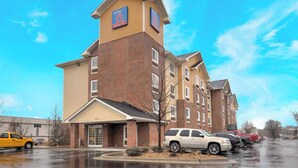 A multi-story hotel with a prominent '6' sign on the facade, a covered entrance, and a parking lot with several vehicles. - 3 Pet-friendly Units w/ Kitchenette | Near Town Center Plaza - 6.7 miles (Johnson County)