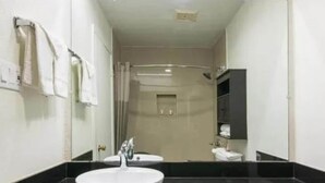 Ein Badezimmer mit einem großen Spiegel, einem Waschbecken und einer Toilette.