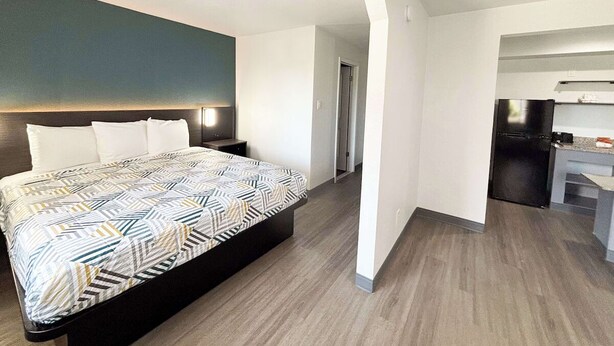 Ein modernes Hotelzimmer mit einem großen Bett, einem Schreibtisch und einer Küchenzeile.