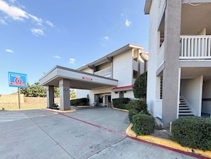 Un hotel de varios pisos con entrada techada, un letrero que dice Studio 6 Extended Stay y cielo despejado.