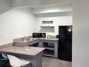 A compact kitchen with a microwave, coffee maker, and a black refrigerator. - Enjoy Affordable Comfort | 2 Units in Central Irving | Pet-Friendly Stay (Irving)