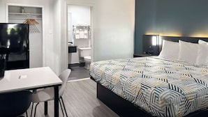 Ein modernes Hotelzimmer mit Bett, Schreibtisch, Stuhl, Kleiderschrank und Bad.