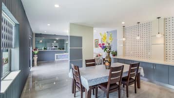 Un comedor moderno con una mesa de mármol, sillas de madera y un jarrón de flores.