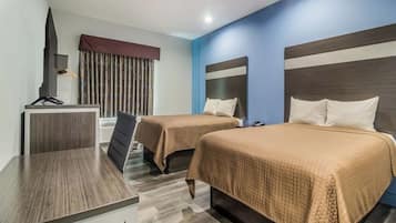 Una habitación de hotel con dos camas, un escritorio y una televisión.