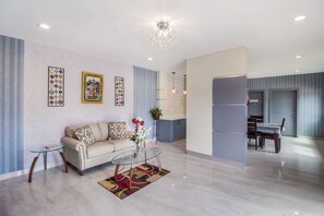 A modern living room with a sofa, glass coffee table, and decorative wall art.