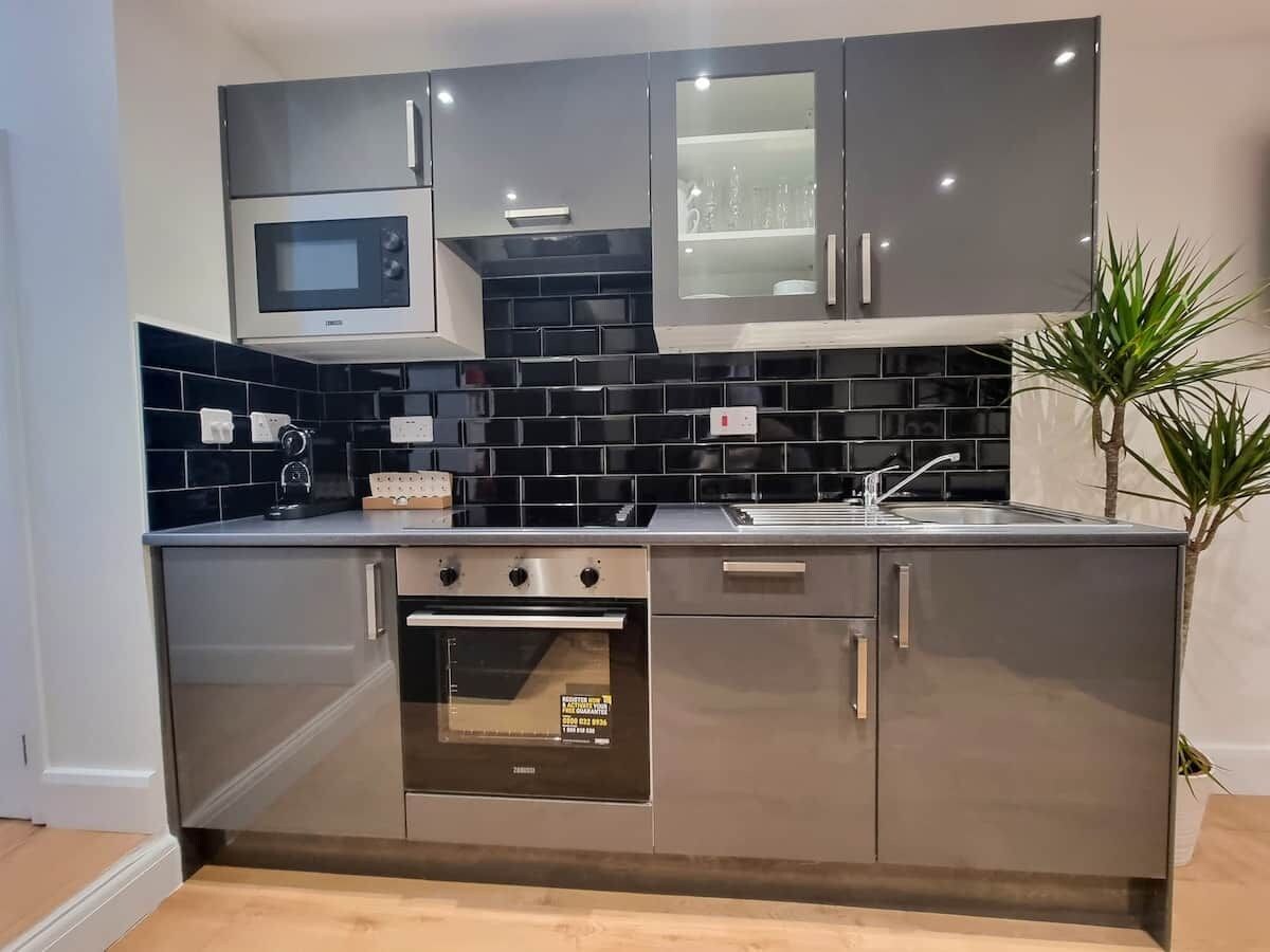 A modern kitchen with a built-in microwave, oven, and sink.