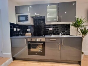 Uma cozinha moderna equipada com micro-ondas, forno e pia.