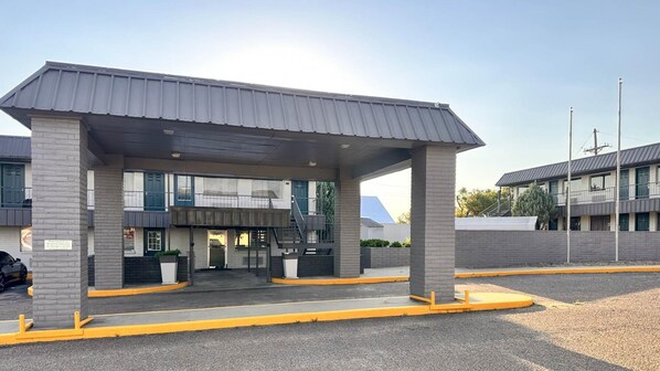 Une station-service dotée d’un auvent, d’un lave-auto et, au fond, d’un bâtiment avec de nombreuses fenêtres.