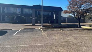 A parking lot with a building in the background.