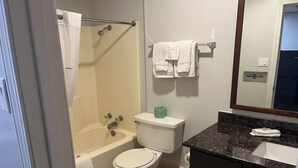 A bathroom with a bathtub, toilet, and sink. - Pet-Friendly Unit w/ 2 Queen Beds | 12 Min Walk to Frank Phillips College (Borger)