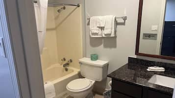 Un baño con bañera, inodoro y lavabo.