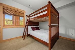 A bunk bed with a ladder, a window with blinds, and a carpeted floor. - Zigzag River Condo 102 at South Grand Lodge | Private Balcony (Government Camp)