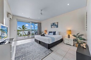 Une chambre moderne dotée d’un grand lit, d’une télévision, d’un balcon avec vue et d’un coin repas.