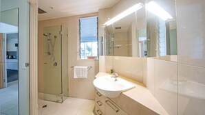 A modern bathroom with a glass-enclosed shower, a large mirror, and a sink with a vanity. - Baybliss Escape #4 - Adults Only (Shute Harbour)