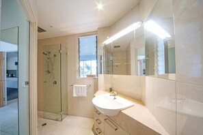 A modern bathroom with a glass-enclosed shower, a large mirror, and a sink with a vanity. - Baybliss Escape #4 - Adults Only (Shute Harbour)
