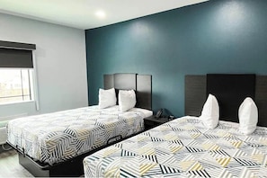 A hotel room with two beds, a window, and a dark teal accent wall. - 3 Budget-Friendly Rooms | 6.4 Miles Away from Airport | Pets Allowed (Houston)