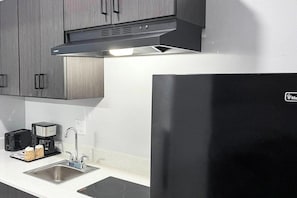 Une cuisine équipée d’appareils électroménagers en acier inoxydable, d’un évier et d’une machine à café.