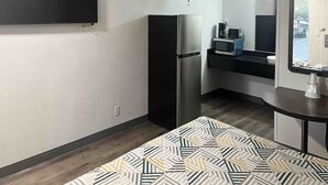 A compact kitchenette with a refrigerator, microwave, and small countertop. - Augusta King Room w/ Kitchenette Near Riverwalk Entertainment (Augusta)