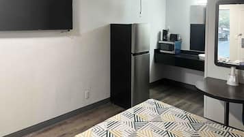 A compact kitchenette with a refrigerator, microwave, and small countertop.