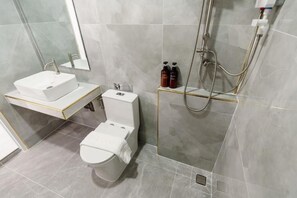 A modern bathroom with a white sink, toilet, and shower. - i2 Resort Lampang (Lampang)