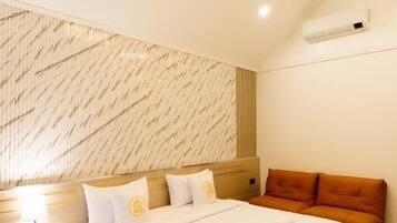 Habitación de hotel con cama, mesita de noche y pared con diseño geométrico.