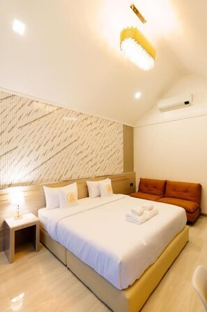 Habitación de hotel con cama, mesita de noche y pared con diseño geométrico.