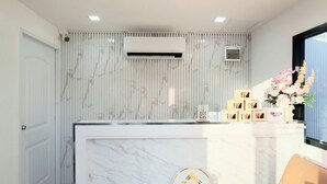 Un mostrador de recepción de hotel con detalles de mármol, una pantalla digital y un logotipo que indica que es un complejo turístico 12.
