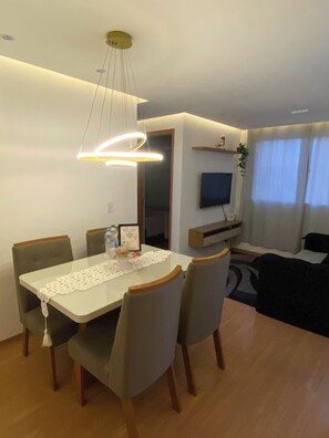 Un comedor moderno con una mesa, sillas y una lámpara colgante.