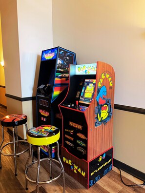 Une borne d’arcade Pac-Man avec un revêtement en bois et un personnage de grenouille sur la façade.