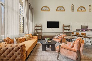 A living room with a sofa, armchairs, a coffee table, and a flat-screen TV mounted on the wall. - New Cozy 3BR Apt - Perfect for Families & Groups (Indianapolis)