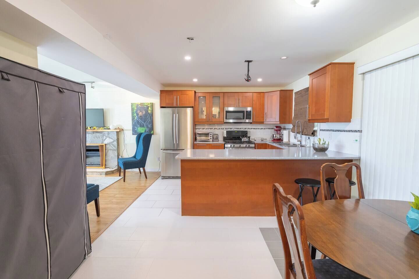 A modern kitchen with wooden cabinets, stainless steel appliances, and a central island.