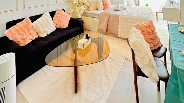 Ein modernes Wohnzimmer mit einer Couch, einem Couchtisch und einem Essbereich mit Tisch und Stühlen.