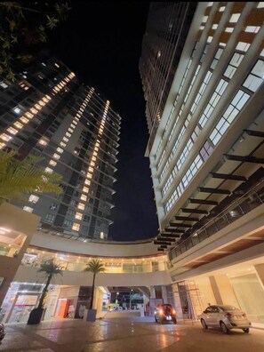 Un edificio a più piani con un design architettonico moderno, caratterizzato da un atrio centrale e un'area di parcheggio.