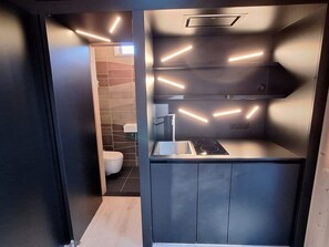 Cozinha compacta com design moderno, equipada com fogão embutido e pia.