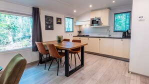 Una cocina moderna con una mesa de comedor, sillas y un microondas.