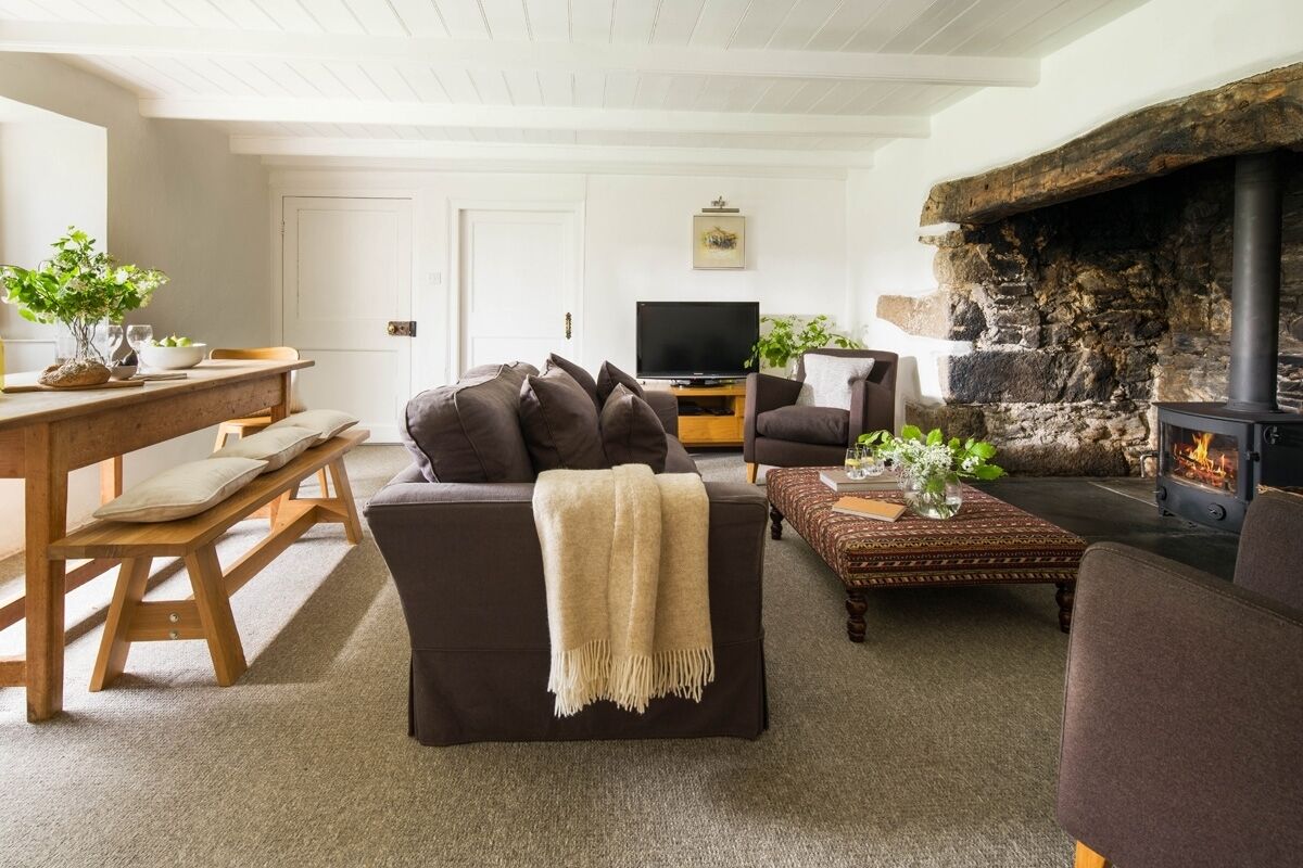 A cozy living room with a fireplace, a sofa, a coffee table, and a television.