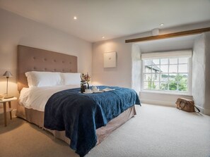 A bedroom with a large bed, a bedside table, a window with a view, and a ceiling light. - Kestle Cottage - sleeps 4 guests  in 2 bedrooms (Helford)