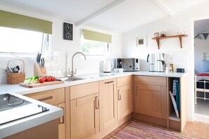 A modern kitchen with wooden cabinets, a stainless steel sink, and a microwave. - Lighthouse View - sleeps 4 guests  in 2 bedrooms (Hayle)