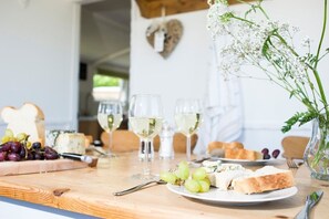 A table set with cheese, grapes, bread, and wine glasses. - Lighthouse View - sleeps 4 guests  in 2 bedrooms (Hayle)